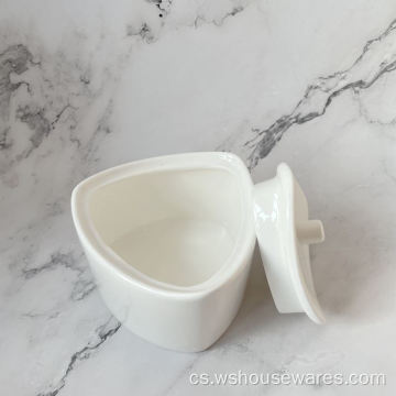 Bílé keramické nádobí s lahví soli